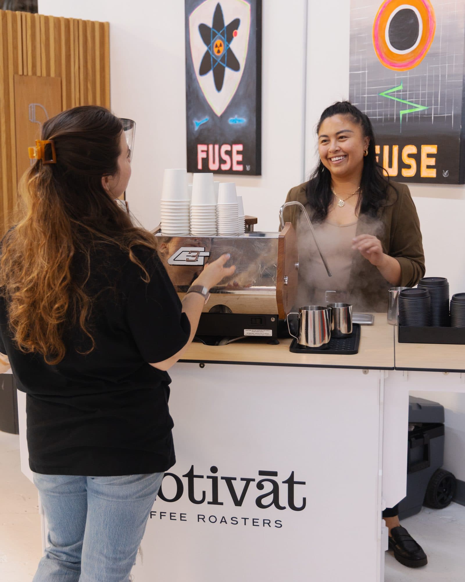 Motivāt baristas steaming milk at the event coffee cart