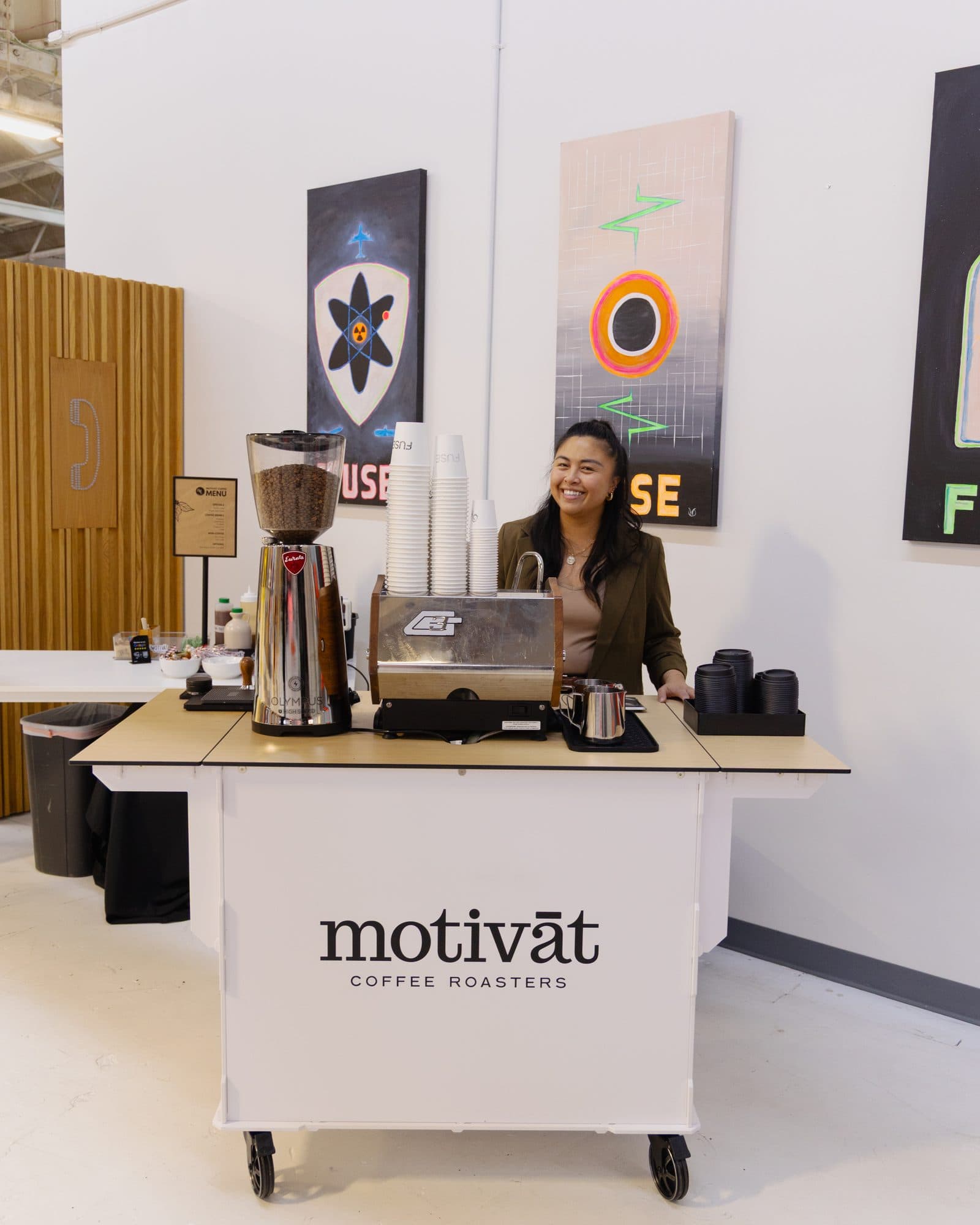 Barista behind the Motivāt espresso cart at an event
